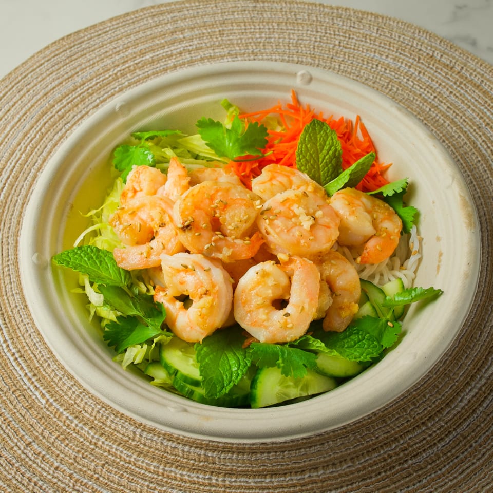 A Vietnamese shrimp bowl with noodles, lettuce, carrots, cucumbers, cilantro, and mint.