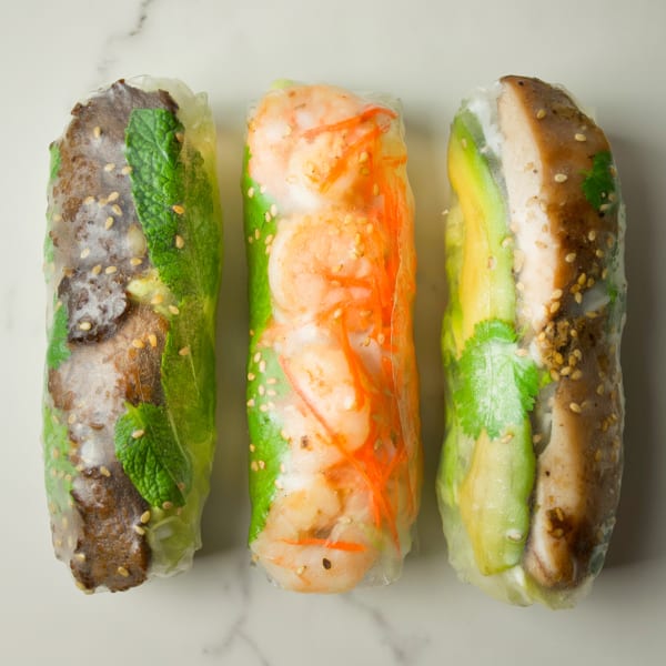 Three CUON Vietnamese fresh rolls, one with beef and mint, one with shrimp and carrots, and one with chicken and avocado.